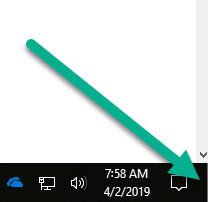 A green arrow points to the area of the taskbar where you can click to show the desktop